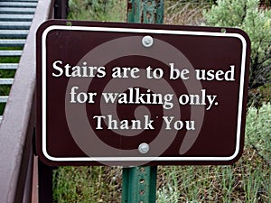 Notice alongside a timber staircase advising it should be used for walking only