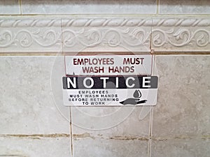 Notice employess must wash hands sign on bathroom wall