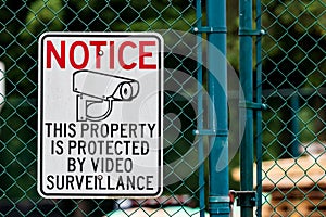 Notice private property video surveillance sign on chain link fence