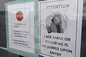 A notice sign instructs visitors to wear a face mask as a stipulated health precaution at the entrance of the medical clinic