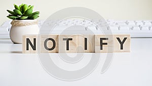 Notify word made with wooden blocks on background white keyboard photo