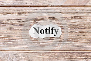Notify of the word on paper. concept. Words of notify on a wooden background