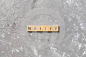NOTIFY word written on wood block. NOTIFY text on cement table for your desing, concept