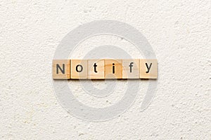 NOTIFY word written on wood block. NOTIFY text on cement table for your desing, concept