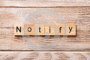 NOTIFY word written on wood block. NOTIFY text on wooden table for your desing, concept