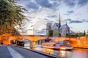 Notre Dame cathedral with boat in the evening, Paris, France
