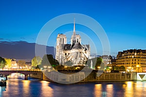 Notre Dame de Paris with cruise ship on Seine river at night in