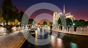 Notre Dame de Paris with cruise ship on Seine river at night in Paris