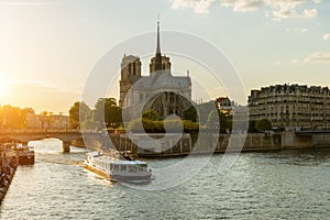 Notre Dame de Paris with cruise ship on Seine river in Paris, Fr