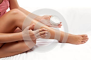 Nourished woman legs with hydrating cream on the skin photo