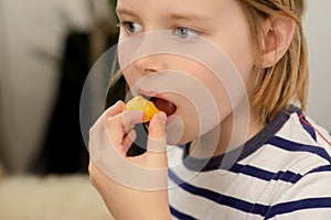 Nourishing bite: A young boy takes a nourishing bite of a juicy yellow plum, relishing the healthful fruit goodness