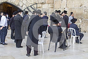 A small group of Hasidic Jews gathered  for prayers, readings and various devotions in a corner of the Western Wall Plaza in