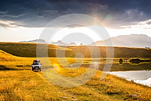 Novakovici, Montenegro - July 20, 2019. Old vintage off road car by paradise Vrazje lake in sunset, Durmitor, Montenegro, Europe