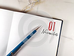 November 01. 01th day of month, pen on the diary on the granite table. Concept of day of year, time planner, autumn month.