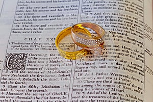 november 04 2016 Wedding rings place on an open Bible to a verse in the book of Genesis marriage.