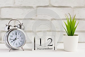 November 12 on the wooden calendar next to the alarm clock, the calendar date of the last autumn month