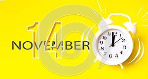 November 14th. Day 14 of month, Calendar date. White alarm clock with calendar day on yellow background. Minimalistic concept of