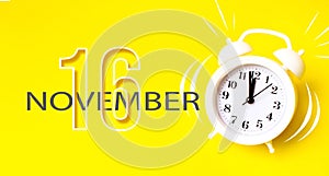 November 16th. Day 16 of month, Calendar date. White alarm clock with calendar day on yellow background. Minimalistic concept of