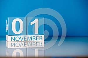 November 1st. Day 1 of last autumn month, calendar on blue background. Empty space for text