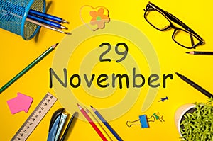 November 29th. Day 29 of last autumn month, calendar on yellow background with office supplies. Business theme