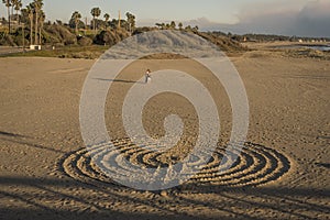 NOVEMBER 9, 2018 - VENTURA, CA, USA - Design in Sand with people at Ventura Pier at sunset, Pacific Ocean