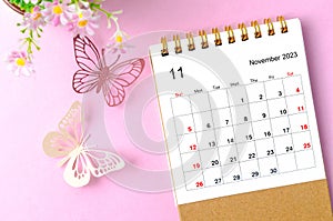 A November 2023 desk calendar for the organizer to plan and reminder and paer butterfly on pink colour background