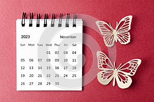 A November 2023 desk calendar for the organizer to plan and reminder with paer butterfly on red background