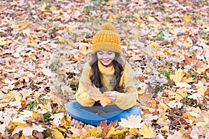 November is here. Child in yellow hat outdoors. Hat keep warm. Kid wear warm soft knitted hat. Warm woolen accessory