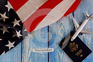 November month of calendar year, travel tourism, emigration the USA American flag with U.S. passport and passenger model plane