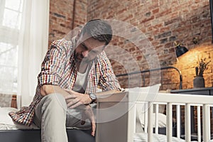 novice dad sitting next to the cradle feeling terrified about his infant baby's future