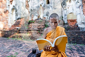 Novice monk reading outdoors