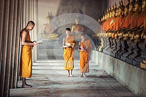 Novice monks reading book inside monastery at Ayutthaya province