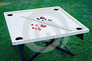 Novuss (also known as koroona or korona) is a large wooden board game where small wooden discs are hit with cue sticks