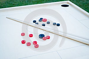 Novuss (also known as koroona or korona) is a large wooden board game where small wooden discs are hit with cue sticks