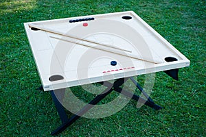 Novuss (also known as koroona or korona) is a large wooden board game where small wooden discs are hit with cue sticks