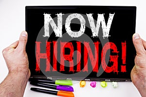 Now Hiring text written on tablet, computer in the office with marker, pen, stationery. Business concept for Recruitment and Job r