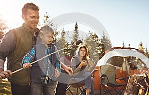 Now its time for smores. a young family camping in the forest.