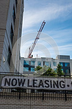 Now leasing sign and newly built apartments