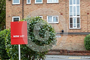 A now Let sign in front of a block of flats in the background