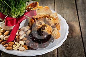 Nowruz holiday concept - grass, baklava sweets, nuts and seeds