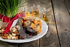 Nowruz holiday concept - grass, baklava sweets, nuts and seeds