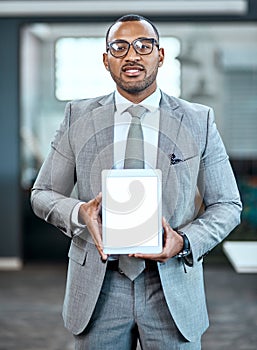 Nows the time to shift your business online. Portrait of a young businessman holding up a digital tablet with a blank