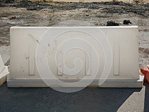 Noyabrsk, Russia - August 9, 2020: A white plastic road block stands on a concrete road to restrict traffic and road works