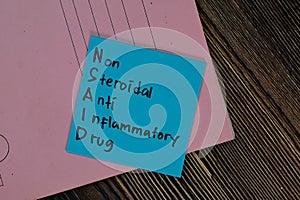NSAID - Non Steroidal Anti Inflammatory Drug write on sticky notes isolated on Wooden Table photo