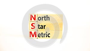 NSM north star metric symbol. Concept words NSM north star metric on wooden blocks on a beautiful white background. Business and