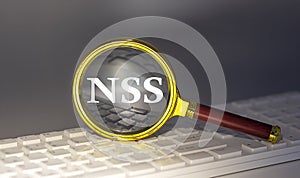 NSS - Network Security Services text on magnifier on a keyboard, business concept