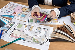 Nterior designerwith color swatch and building plans on office photo