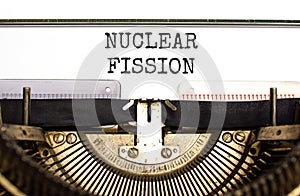 Nuclear fission symbol. Concept words Nuclear fission typed on beautiful old retro typewriter. Beautiful white paper background.