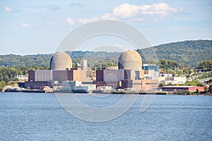 Nuclear power plant along a river w forested hills in background