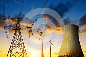 Nuclear power plant with wind turbines and electricity pylon in the sunset.